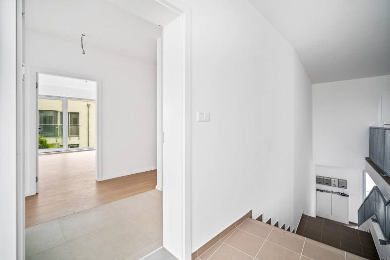 Interior of a 4-room apartment with a staircase and flooring with a wooden decor.