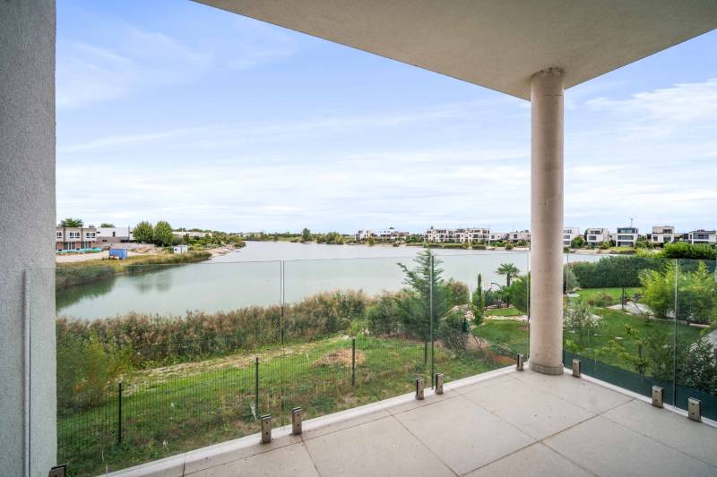 A balcony with a view of the lake and modern residential buildings in Kittsee, 4-room apartment.