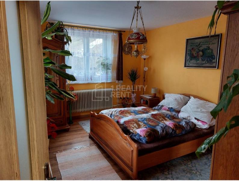 Bedroom in a family house with a wooden decor floor and plants.
