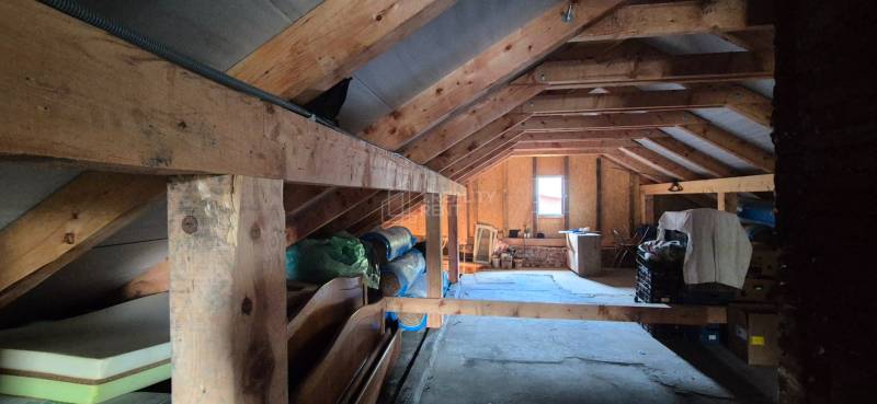 Attic of a family house with wooden beams and storage space.