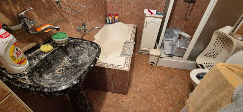 Bathroom in a family house with a sink, bathtub, and shower.