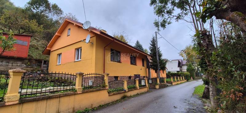 A family house on Škoruby in Kolárovice with a colorful facade and a small yard.