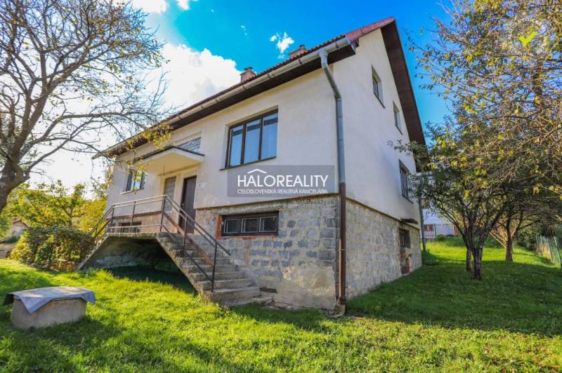 A family house in Papradno, a two-story building with large windows and stairs, surrounded by greenery.
