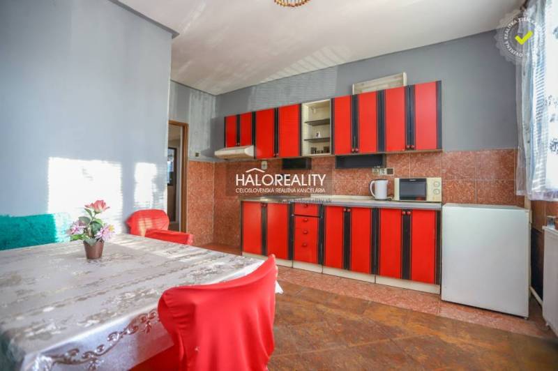 A kitchen with red cabinets and a dining table in a family house.