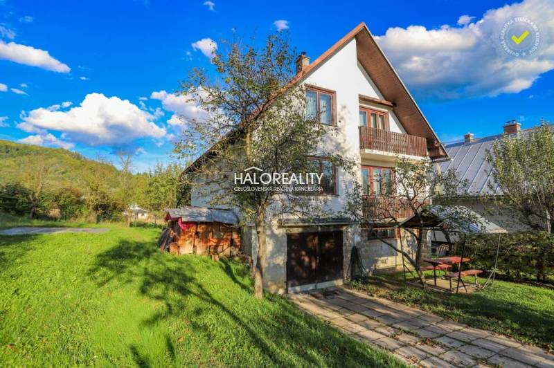 A family house in Papradno with a large garden, trees, and a wooden tool shed.