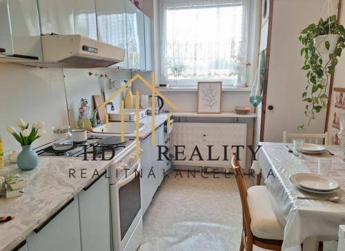 A kitchen in a 3-room apartment with an extended dining table and light accessories.