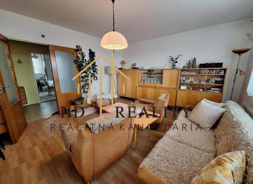 Living room with a comfortable sofa and wooden decor flooring in a 3-room apartment.