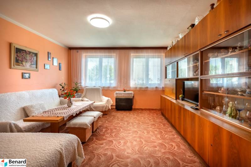 Living room in a 3-room apartment with a sofa, built-in wardrobe, and carpet.