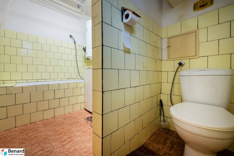 Bathroom in a 3-room apartment with yellow tiles, a bathtub, and a toilet.