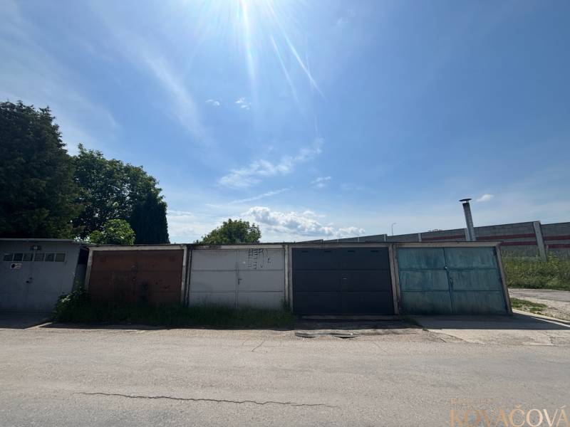 Garages on Legionárska Street in Trenčín, sky with light clouds and trees.