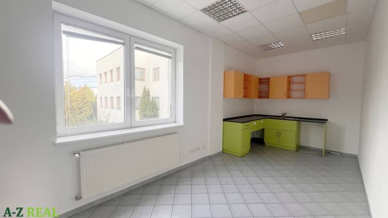 Offices with tiled floors, white walls, a large window, and a colorful kitchen unit.