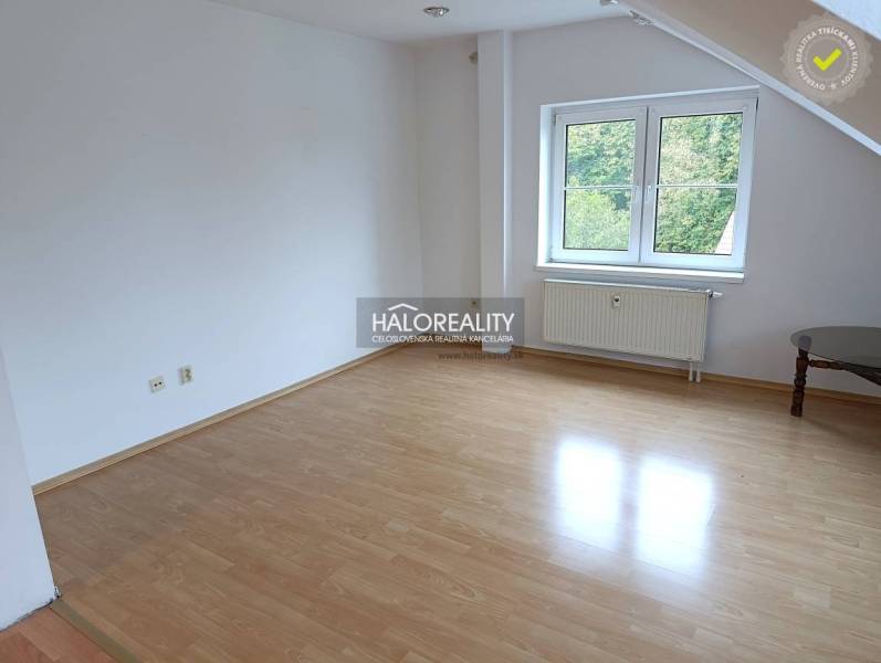 A room in a 2-room apartment with a wooden decor floor and a window.