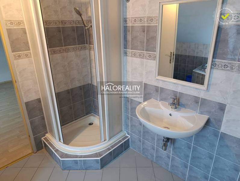 A bathroom with a built-in bathtub, tiles, and a skylight in a 2-room apartment.