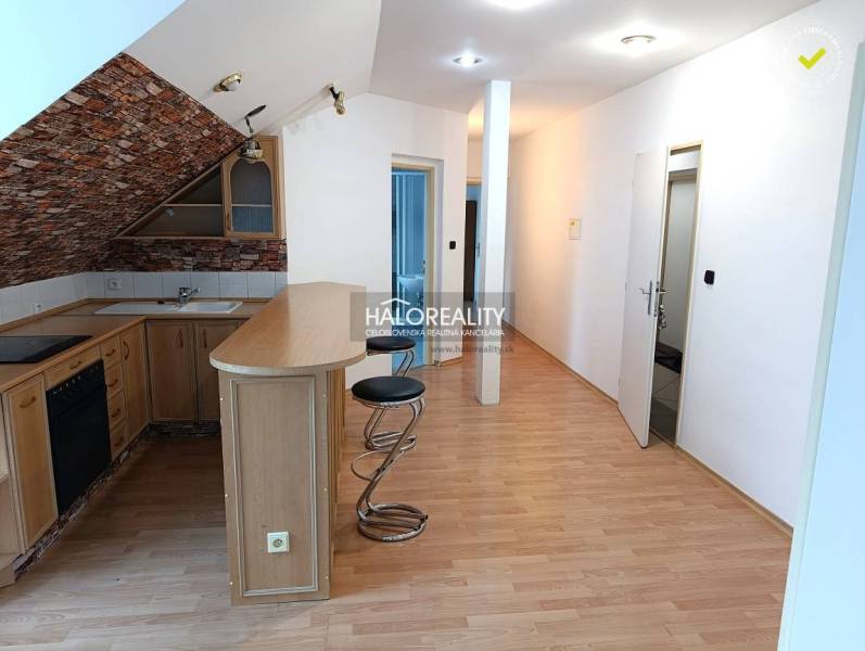 Interior of a 2-room apartment with a kitchenette and a wooden decor floor.