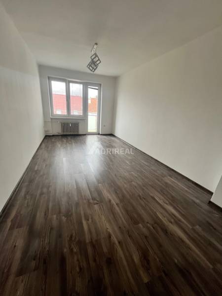 A room in a 3-room apartment with a wood-decor floor and large windows.