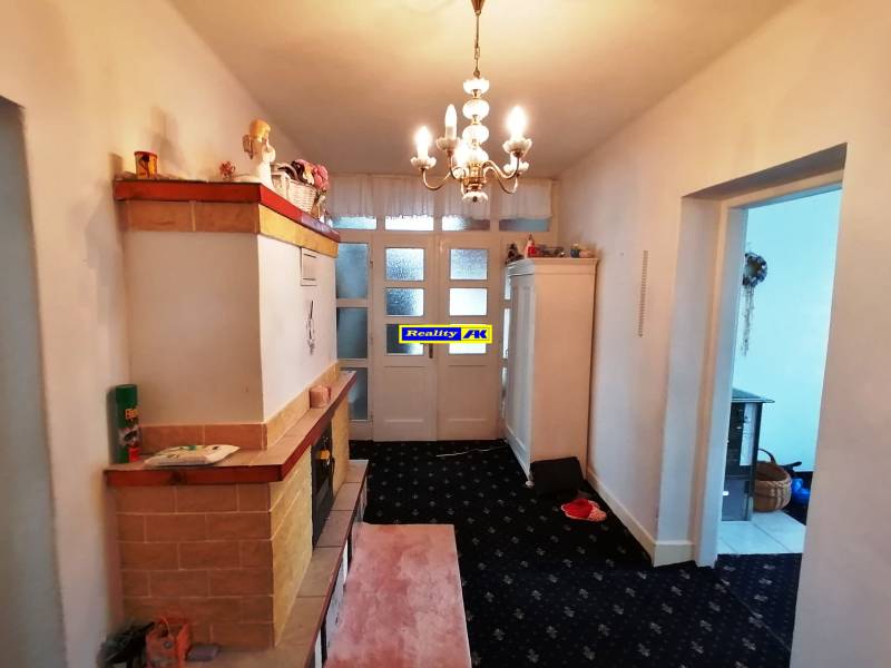A hallway in a 3-room apartment with light furniture, carpeted floor, and a chandelier.