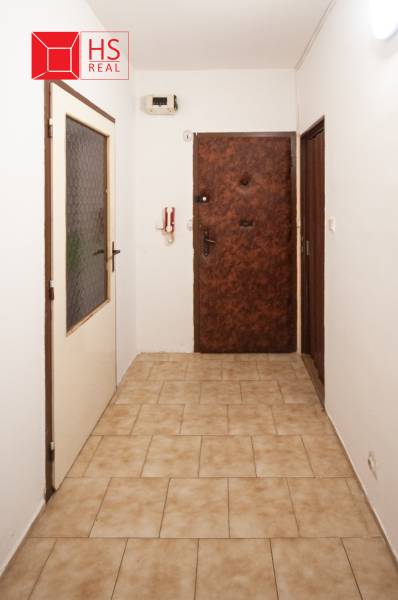 Hallway in a 3-room apartment with doors and tiles.