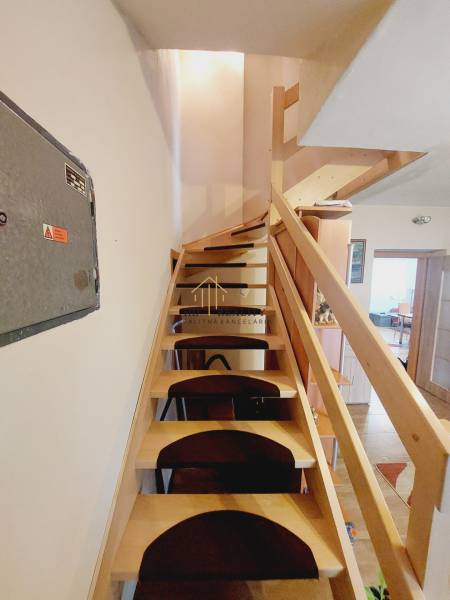 Wooden stairs with safety railing in a family house with an open space.