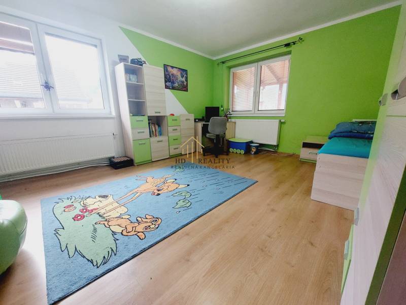 Children's room with colorful walls, a wooden decor floor, and a carpet with a motif.