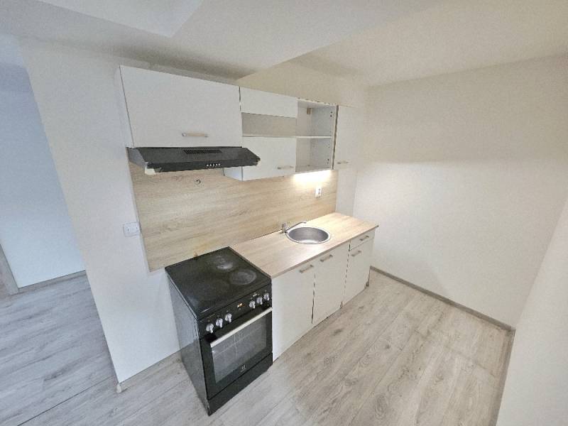 A kitchen unit with a wooden decor floor in a 3-room apartment.