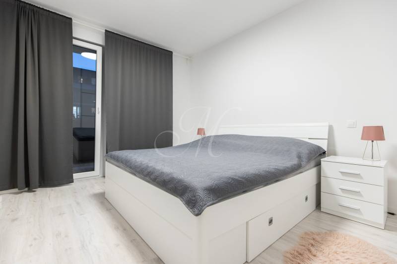 Bedroom with a bed, nightstands, and curtains in a two-room apartment.