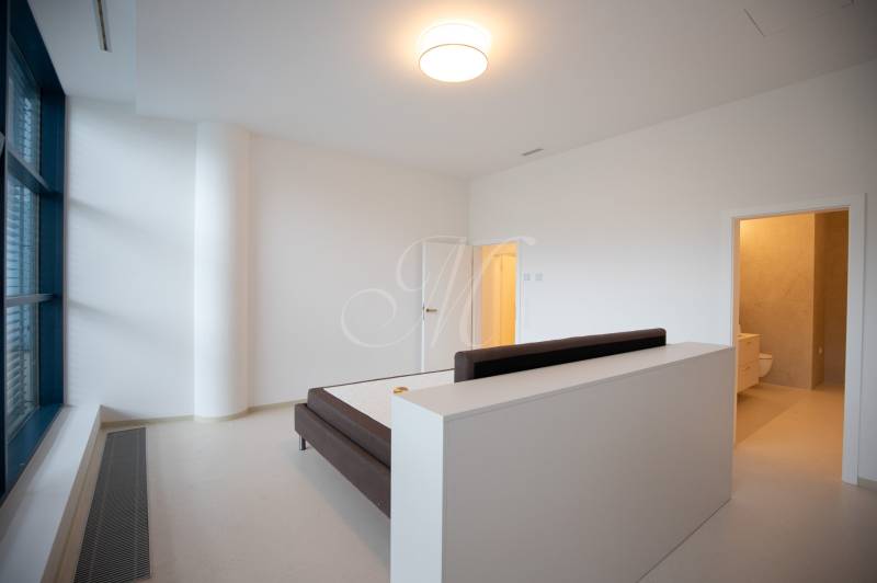 Bedroom in a 4-room apartment with a bed, window, and entrance to the bathroom.