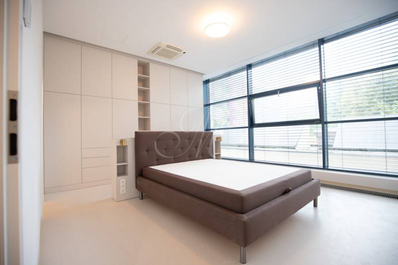 A bright bedroom with large windows and a built-in wardrobe in a four-room apartment.