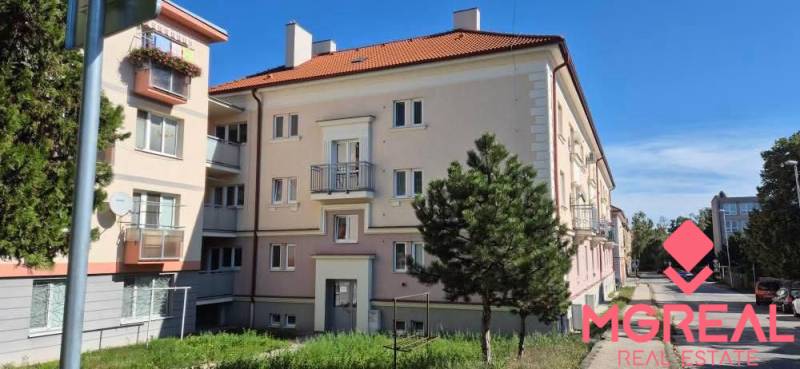 An older brick building with balconies and a red roof, suitable for a 2-room apartment in Nitra.