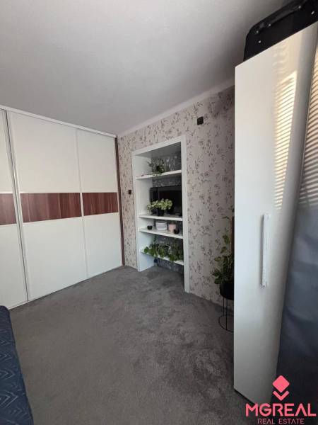 A cozy room in a two-room apartment with flowers and a built-in wardrobe.