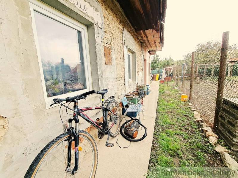 Bicycle and tools at a family house with a stone facade in Ľudovítová.