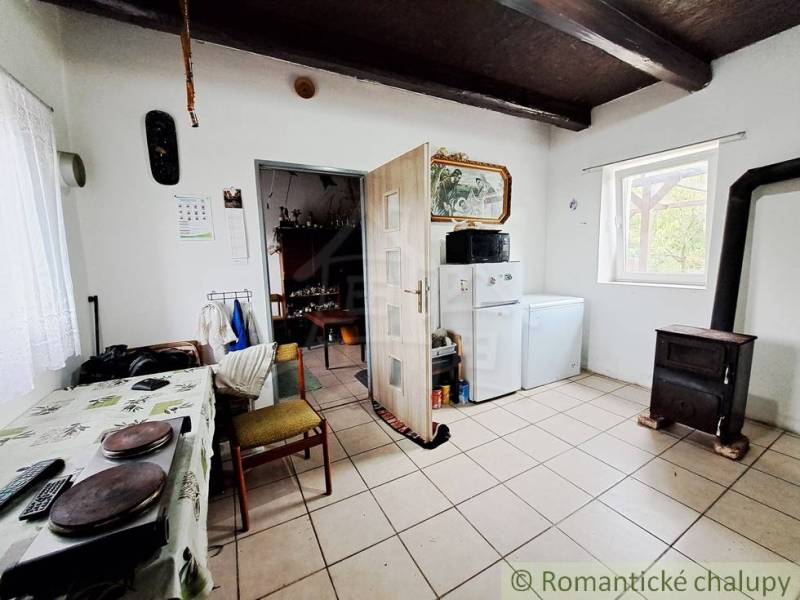 A kitchen in a family house with a stove and a refrigerator, the floor is light tiles.