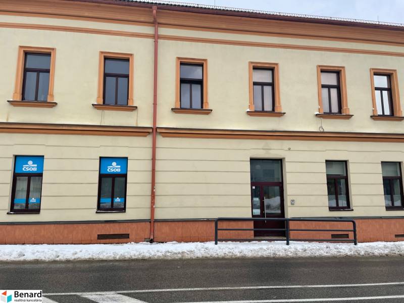 A building with commercial spaces on St. Nicholas Square in Stará Ľubovňa covered with snow.