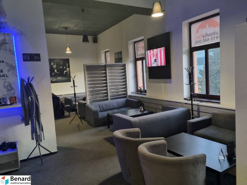 Bright commercial space with comfortable seating and a television on the wall.