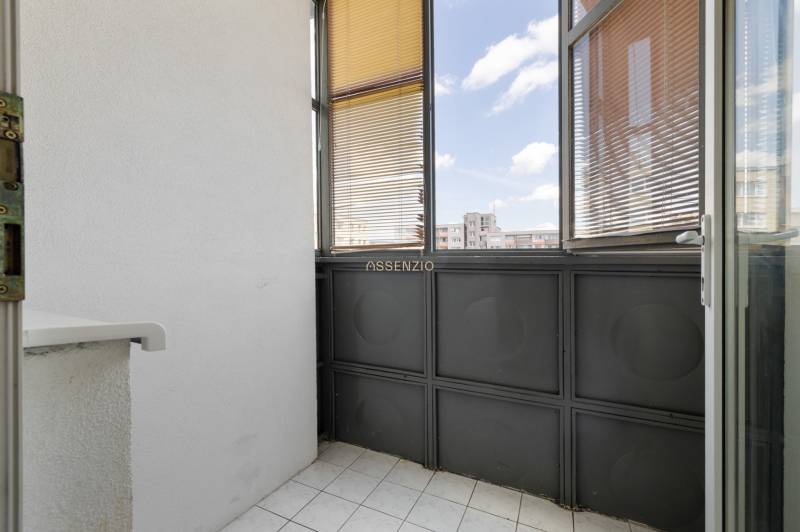 Glazed loggia with white tiles in a 3-room apartment.