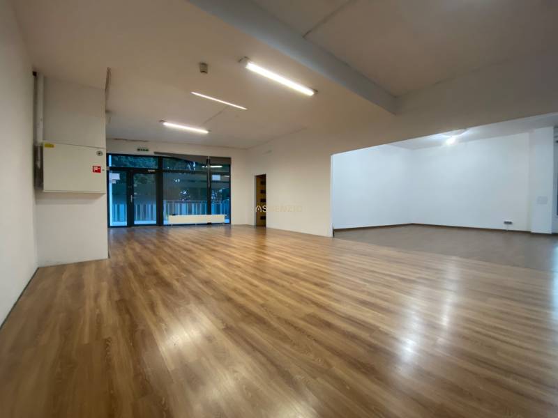 Commercial spaces with wood-patterned flooring and light panels.