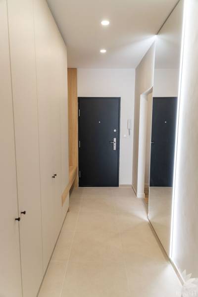 Entrance hall in a 4-room apartment, with tiles and a large mirror.
