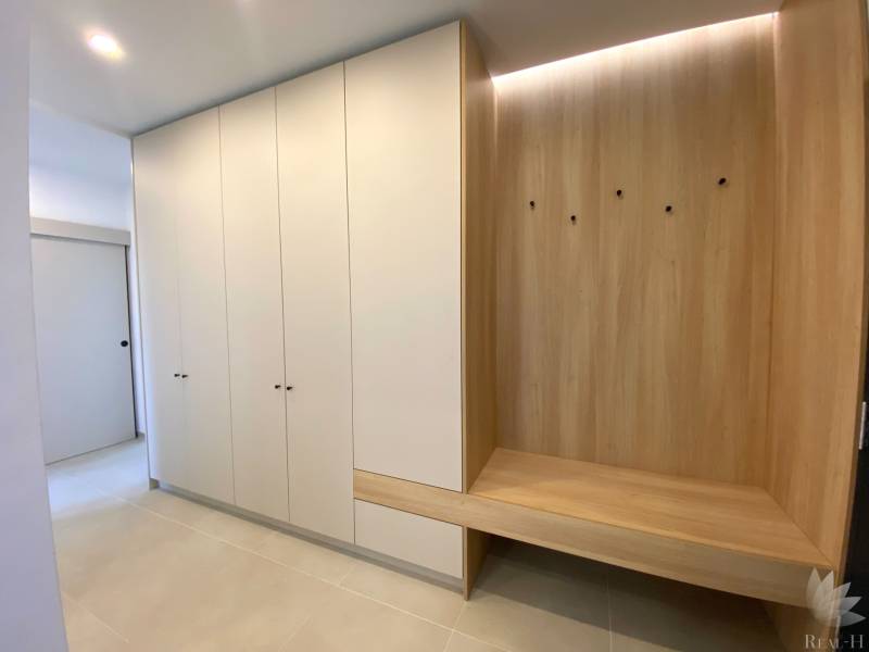 Built-in wardrobe and bench with wood decor in a 4-room apartment.