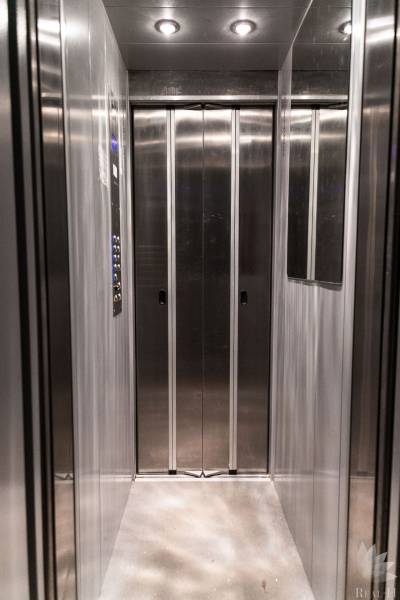 Stainless steel elevator with lighting and mirror in a 4-room apartment.