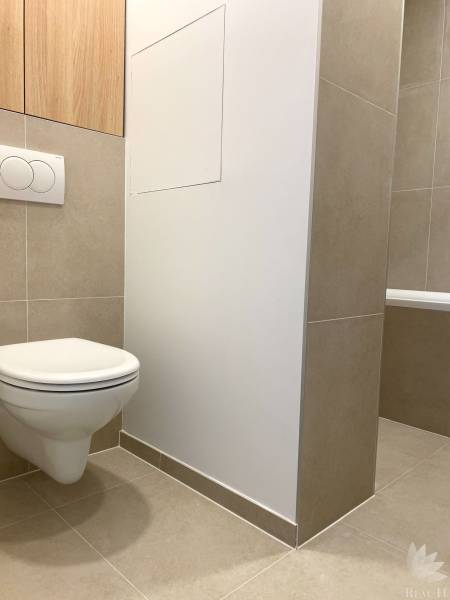 Bathroom with wall-hung toilet and tiles in a 4-room apartment.