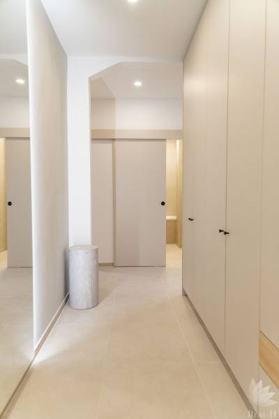 A hallway with tiles and built-in wardrobes in a 4-room apartment.