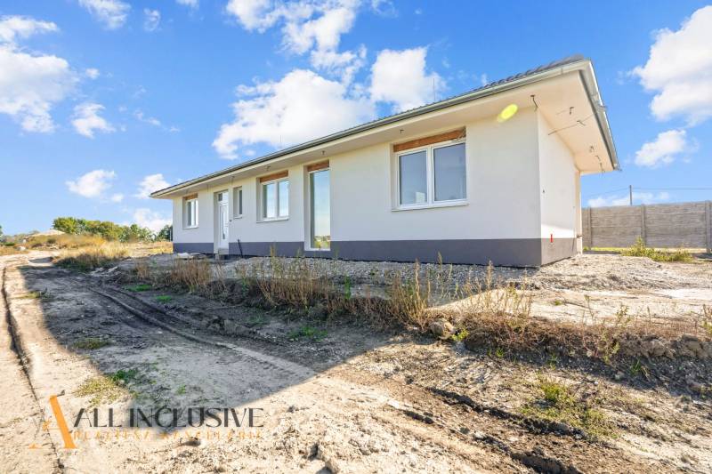 A family house in Gabčíkovo with a simple white facade surrounded by nature.