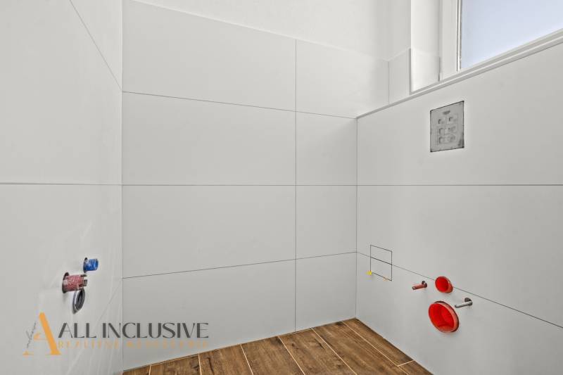 A family house bathroom with a wooden decor floor and white tiles.