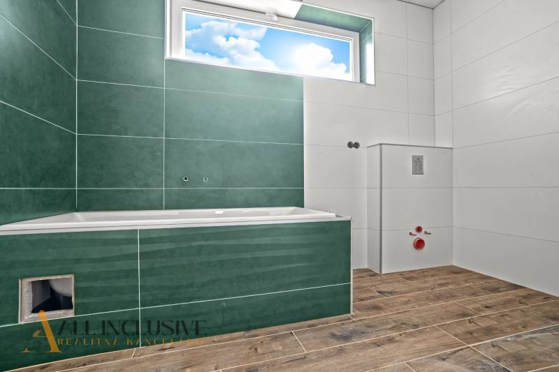 A bathroom in a family house with a bathtub and a floor with a wooden decor.