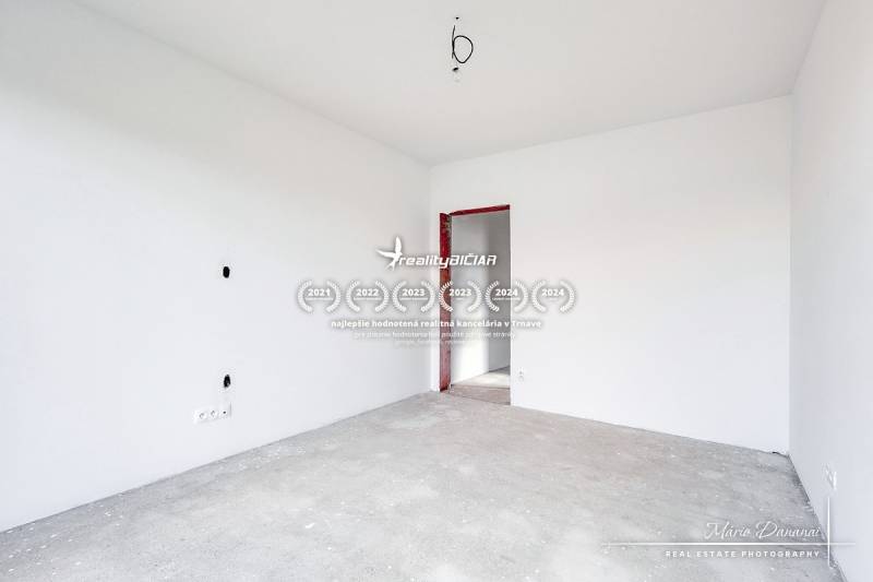 Empty room with white walls and a concrete floor in a family house.