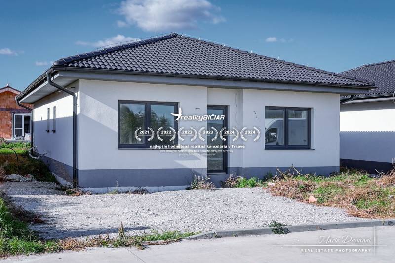 A family house in Slovenská Nová Ves on Slovenská Nová Ves street with a dark roof and parking lot.
