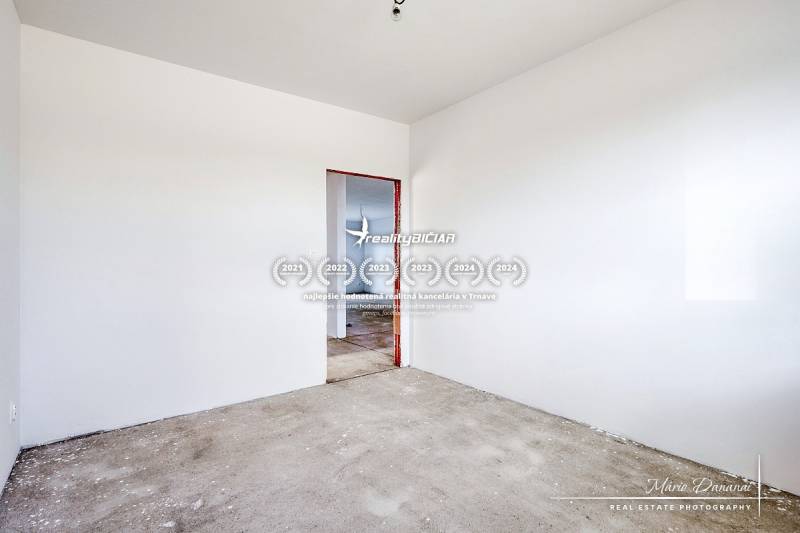 Empty room with white walls and a concrete floor in a family house.
