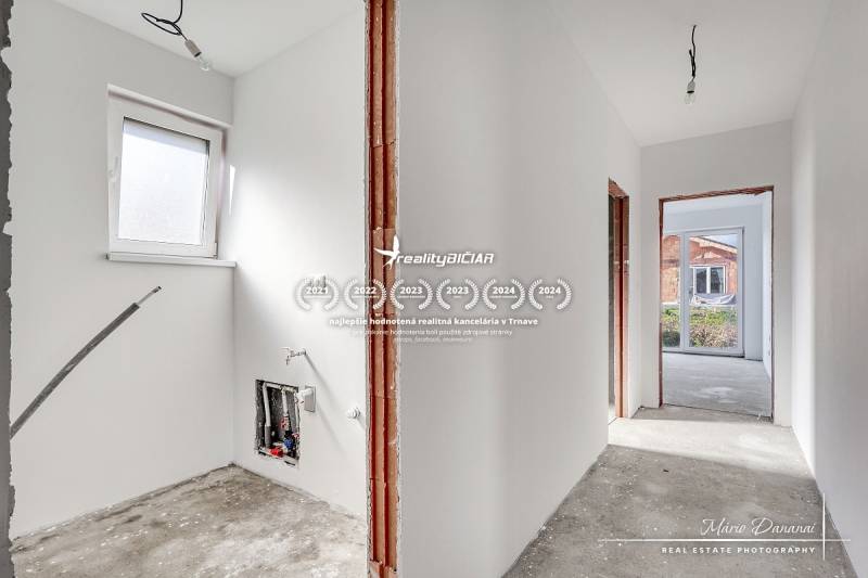 The interior of a family house with an unfinished floor and white walls.