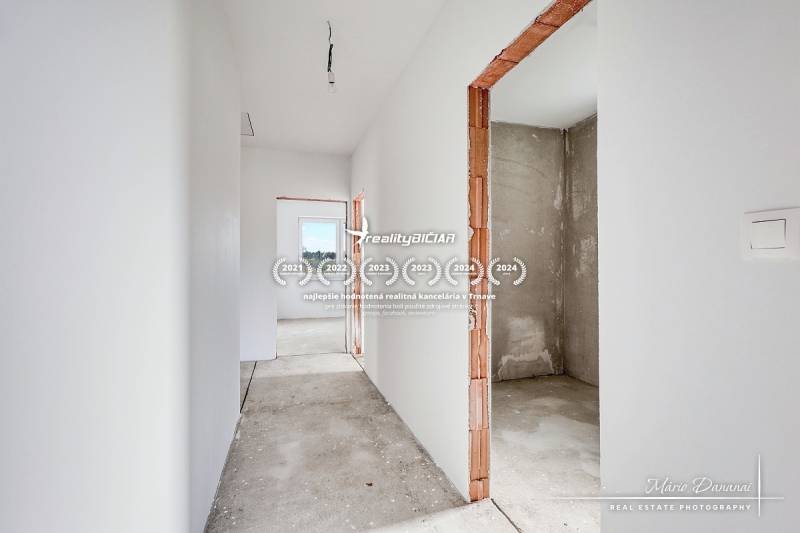 Interior of a family house with unfinished walls and a view of the concrete floor.