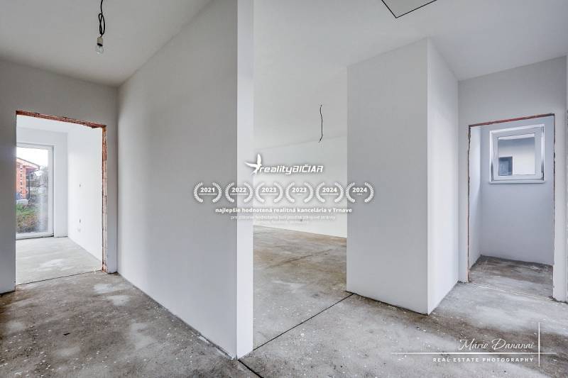 A hallway in an unfinished family house with a concrete floor and white walls.