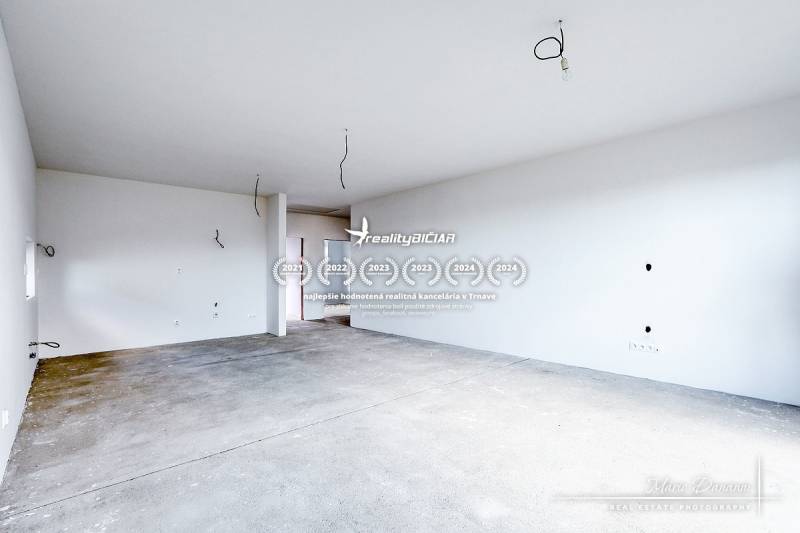 Spacious room in a family house with bare floor and unfinished walls.